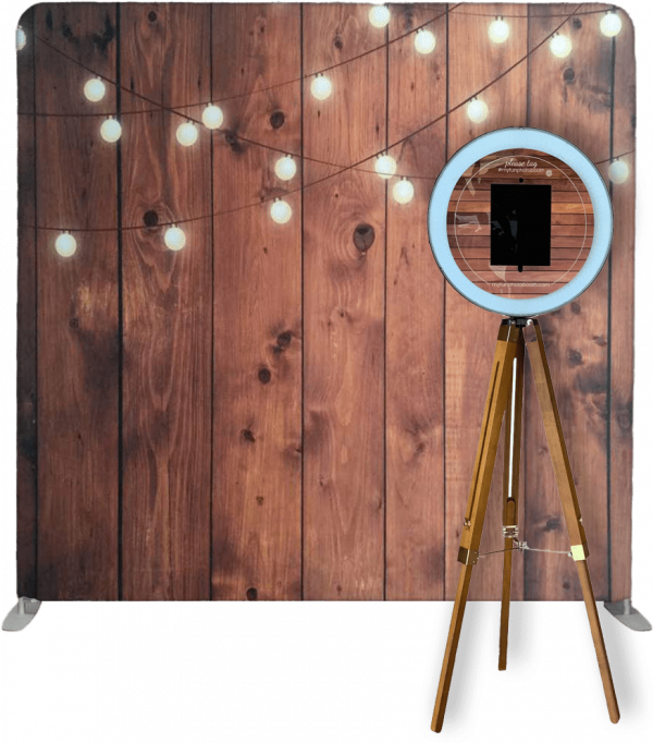 BoothCloud photo booth setup, ring light, iPad, gold tripod, wooden festoon-light backdrop